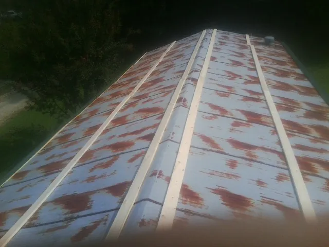 Rusted metal roof panels with new wood purlins before replacement — Storm Damage Roof Repair in Waban by Roofing Brothers