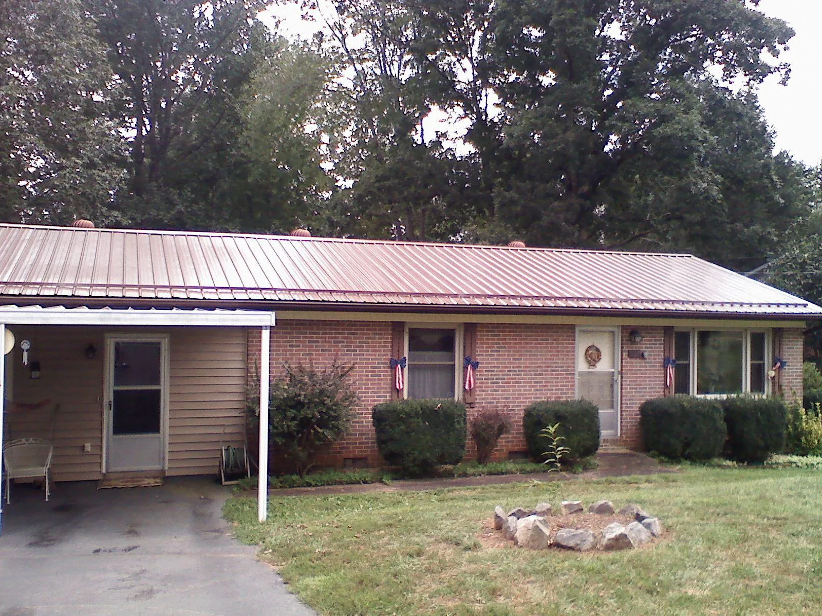 Bronze metal roof and carport on a brick ranch home — Roof Repair work by our crew in Waban